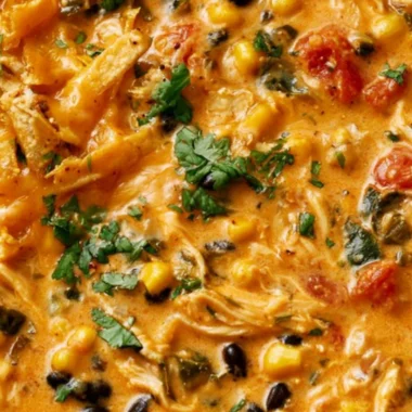 Bowl of creamy chicken tortilla soup with tortilla strips and toppings