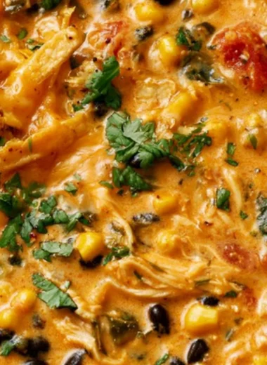 Bowl of creamy chicken tortilla soup with tortilla strips and toppings