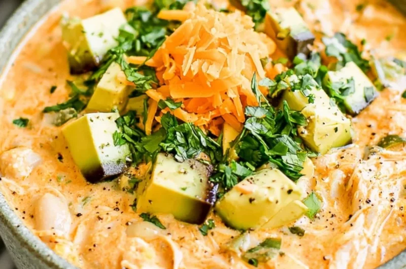 Bowl of healthy high protein white chicken chili topped with cilantro and cheese