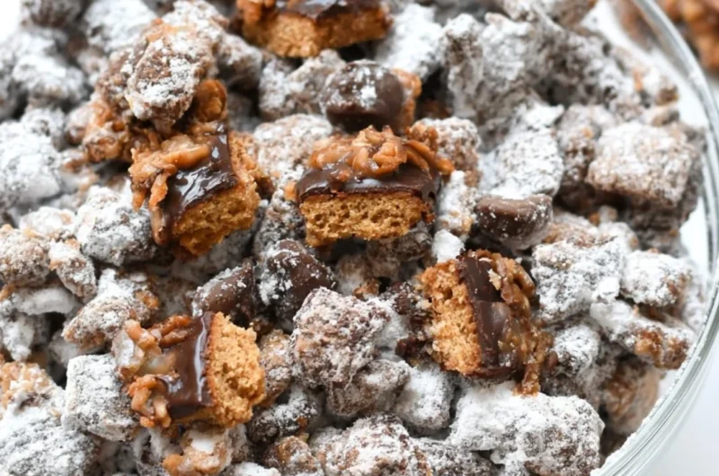 Samoas Puppy Chow snack mix featuring chocolate, caramel, and toasted coconut.