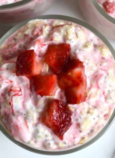 Bowl of strawberries and cream overnight oats topped with fresh strawberries
