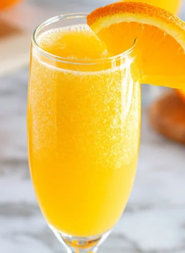 Refreshing non-alcoholic mimosa served in a glass with citrus garnishes