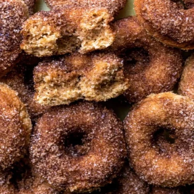 Delicious baked apple cider donuts arranged on a rustic wooden table