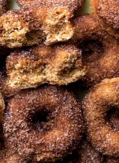 Delicious baked apple cider donuts arranged on a rustic wooden table