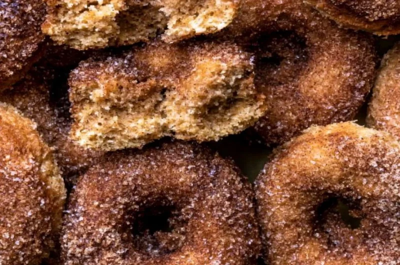 Delicious baked apple cider donuts arranged on a rustic wooden table