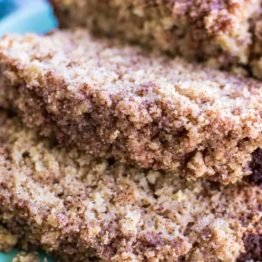 Slice of coffee cake banana bread on a plate with a coffee cup