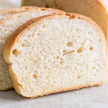 Loaf of soft sourdough sandwich bread on a wooden cutting board