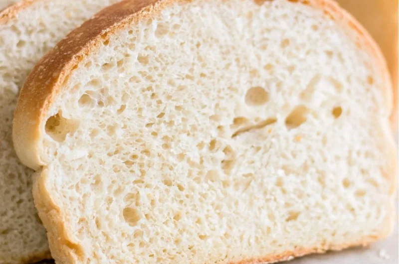 Loaf of soft sourdough sandwich bread on a wooden cutting board