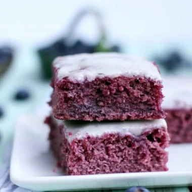Cozy glazed blueberry brownies topped with a sweet glaze and fresh blueberries.