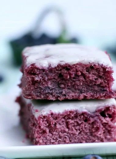 Cozy glazed blueberry brownies topped with a sweet glaze and fresh blueberries.