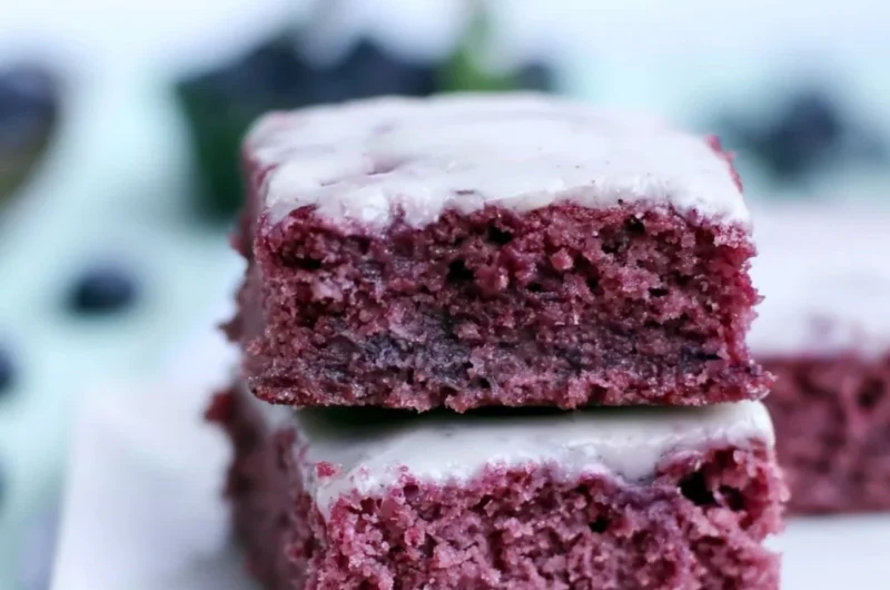 Cozy glazed blueberry brownies topped with a sweet glaze and fresh blueberries.