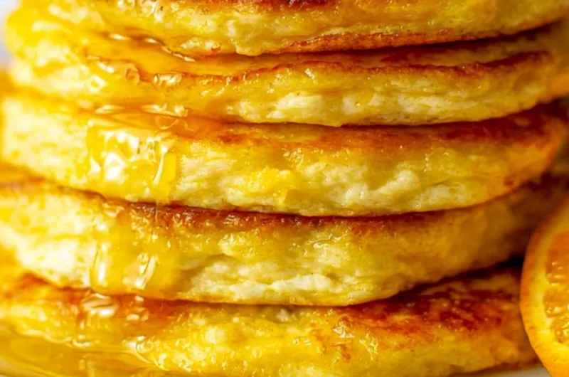 Delicious orange ricotta pancakes topped with fresh fruits and syrup.