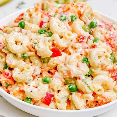 Creamy macaroni salad with vegetables and dressing in a serving bowl