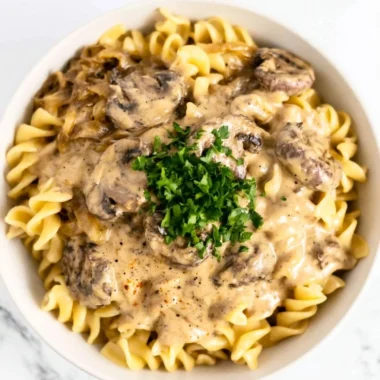 Creamy vegetarian mushroom stroganoff served in a bowl with a sprinkle of herbs.