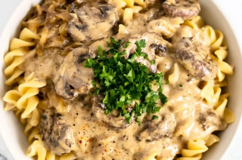 Creamy vegetarian mushroom stroganoff served in a bowl with a sprinkle of herbs.