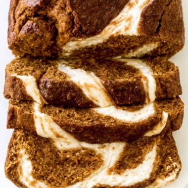 Slice of moist Pumpkin Cream Cheese Bread on a wooden board