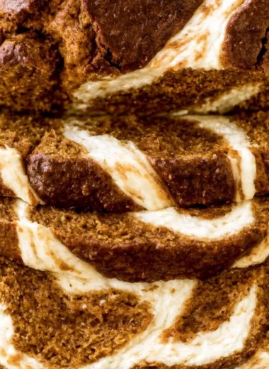Slice of moist Pumpkin Cream Cheese Bread on a wooden board