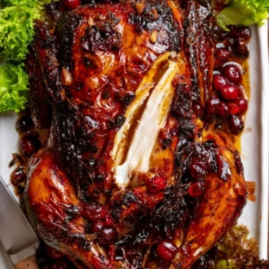 Whole roast chicken with cranberry-maple glaze served on a festive table